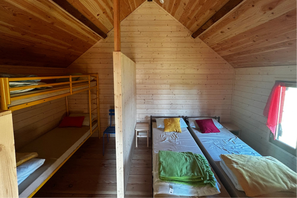 Dortoir aux Granges de la Brasque, deux lits simples, un lit superposé dans une cabane. Refuge de randonnée situé sur le GR5